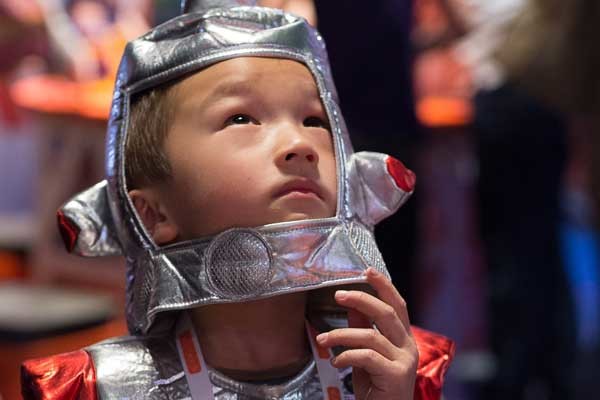 A young boy wearing a soft astronaut costume