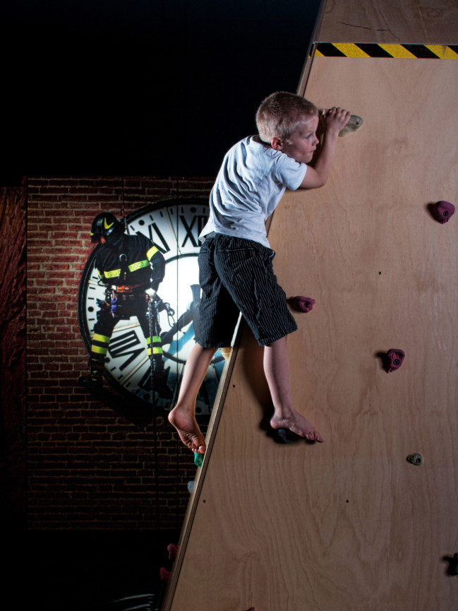 A young boy climbing on the Bouldering wall in the Rescue Exhibit.