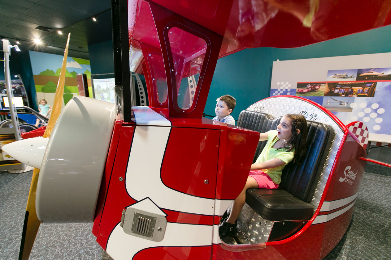 Two young children operating the flight simulator exhibit at Scitech's Going Places.