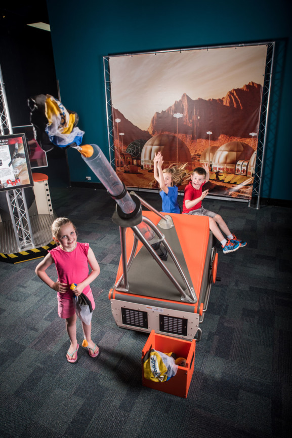 Three young children shooting off a canon in a Scitech exhibit.