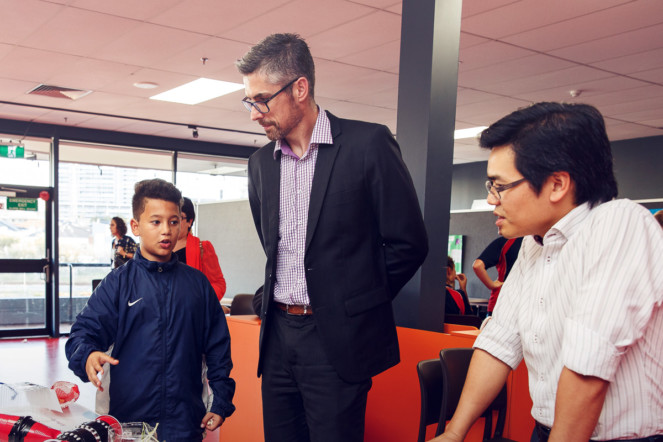 Two professional adults listening to a young boy.