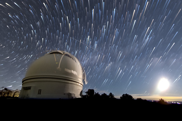 Time lapse of starry night sky above a planetarium.