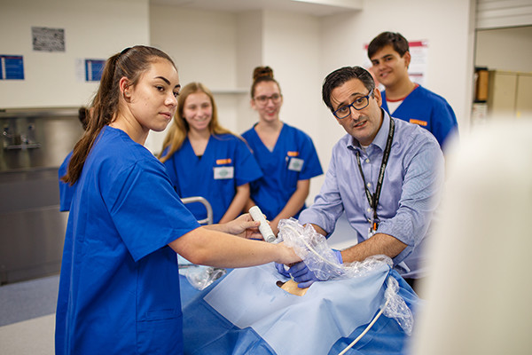 A doctor showing students a medical procedure for a education program.