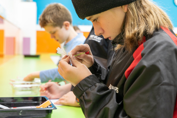 Students at a desk crafting paper plants.