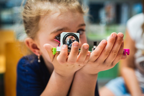 Young girl holding up electronic creation.