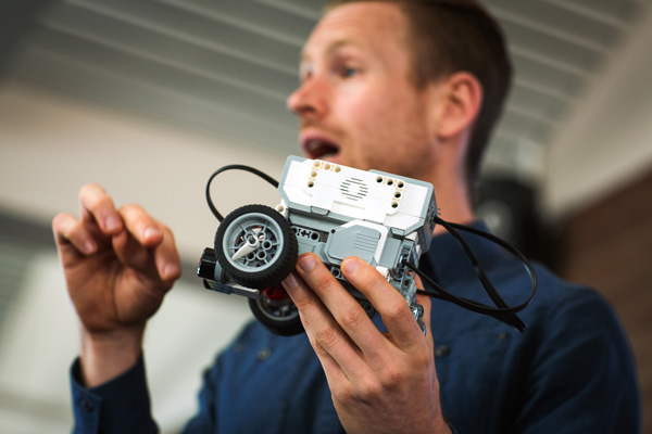 Close up of a teacher holding a robotic machine.