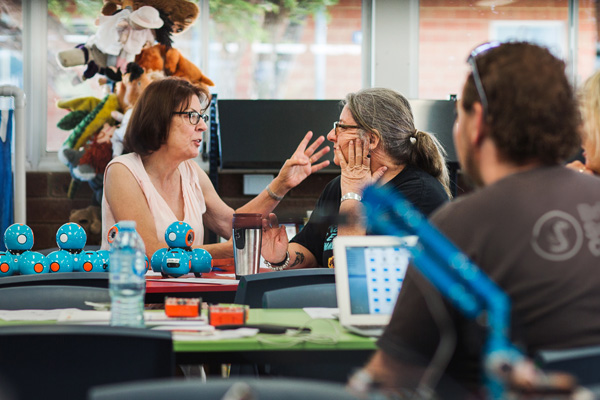 Two teachers talking at a professional learning workshop.