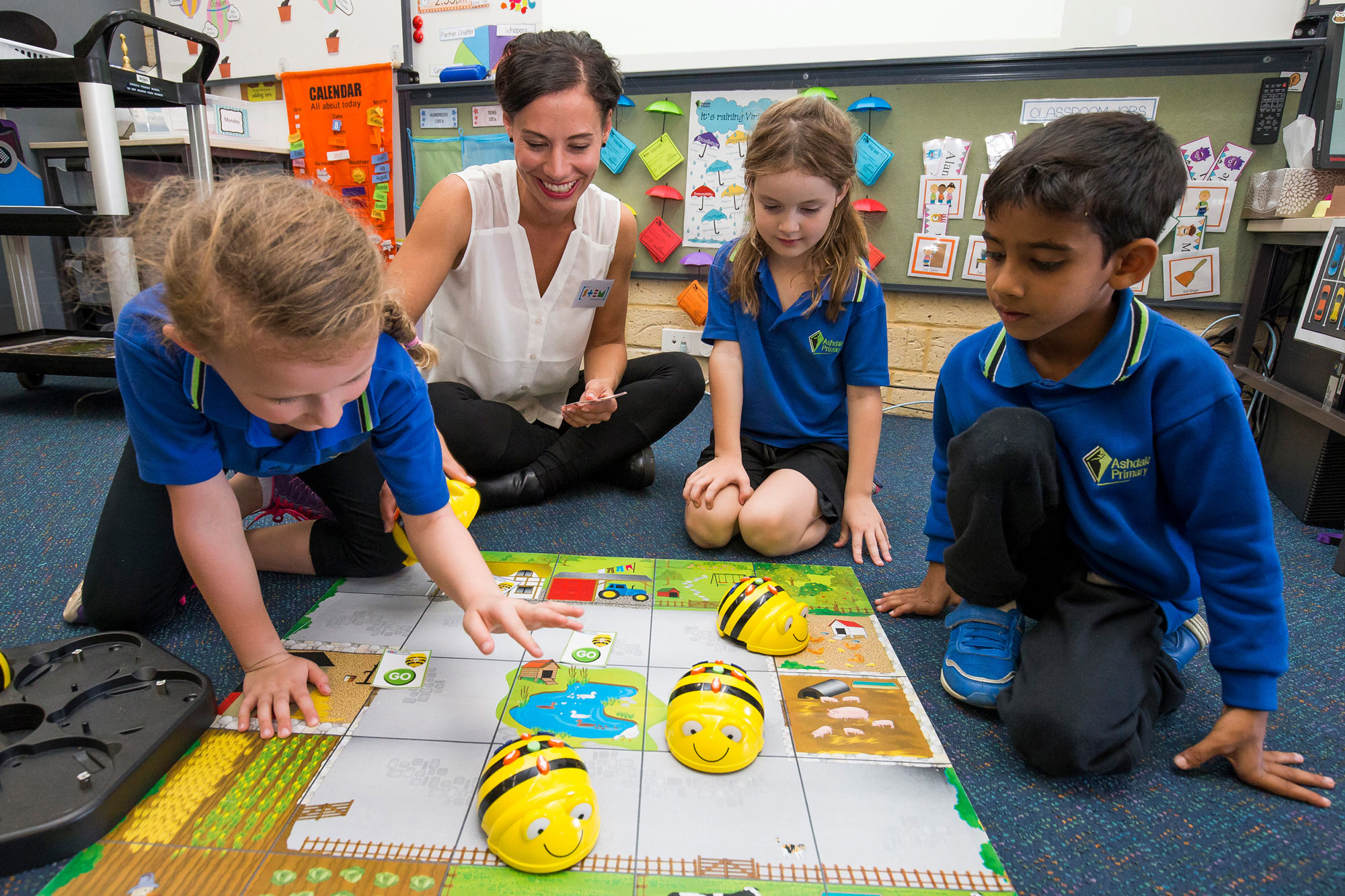 Teacher and group of primary students completing a STEM learning activity in the classroom.