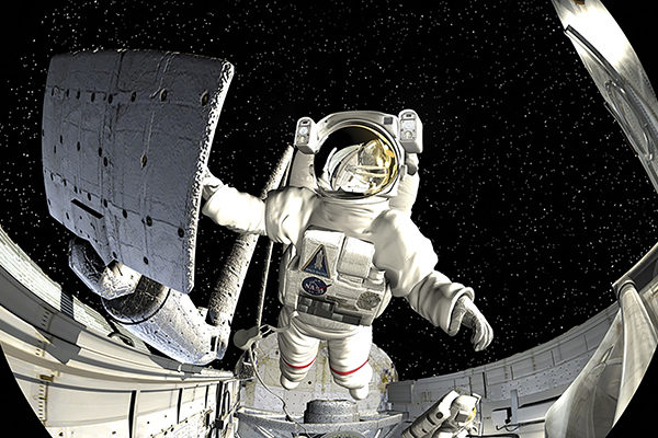 An astronaut floating in space while holding onto the International Space Station.