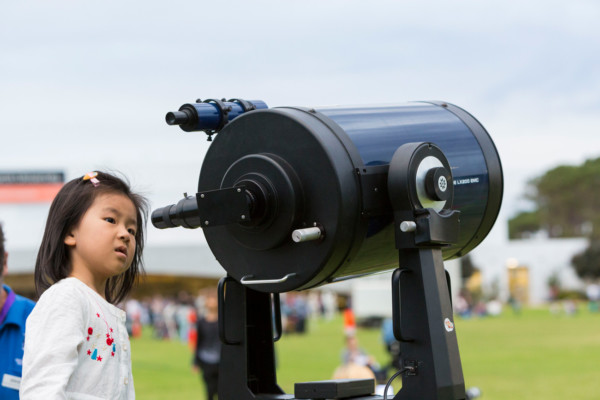 Girl looking through a telescope at astrofest.