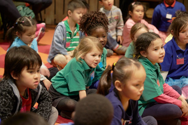 Row of school kids engaged in puppet show