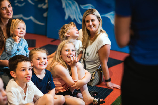 Two mums and kids watching a puppet show