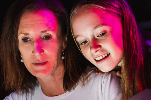 Close up of a teenage girl and her mum with inquisitive looks.