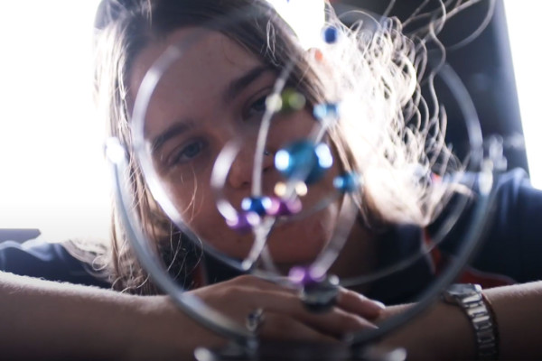 A close up of a young girls face as she looks at a the camera with curiosity.