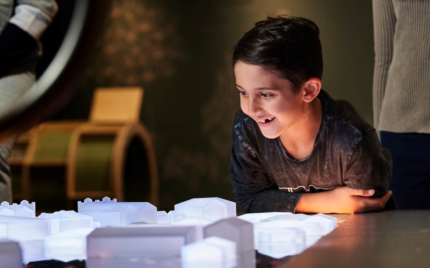 Boy amazed at 3D printed buildings lit up by LED lighting