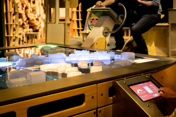 Person on cycle in the background with a model city.