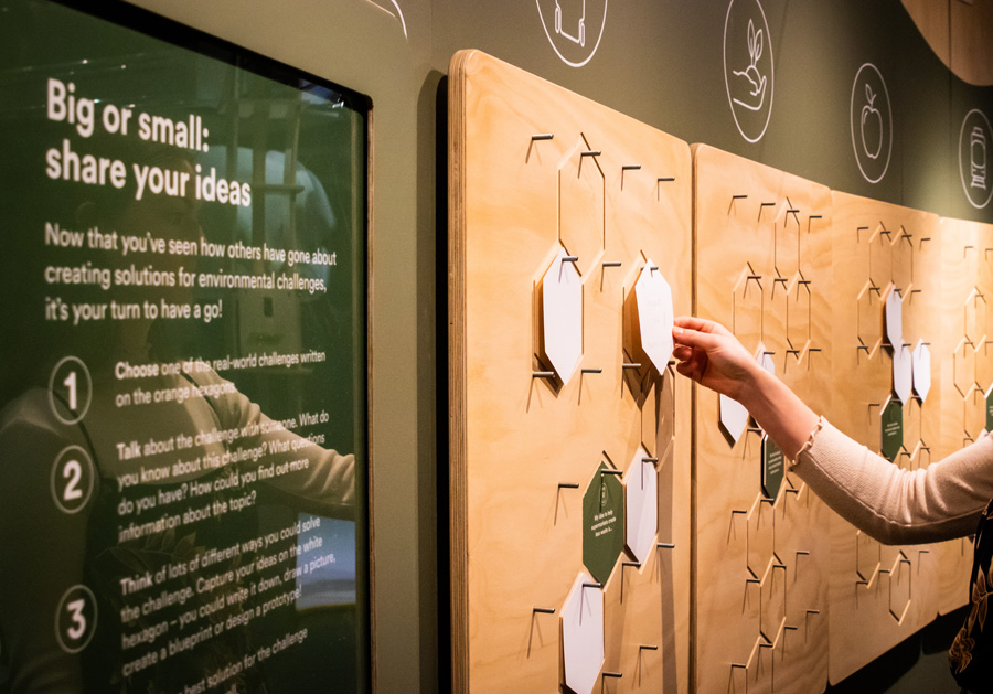 Hand placing written ideas about sustainability on a wall