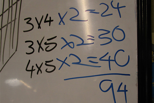 Closeup of multiplication equations on a whiteboard.