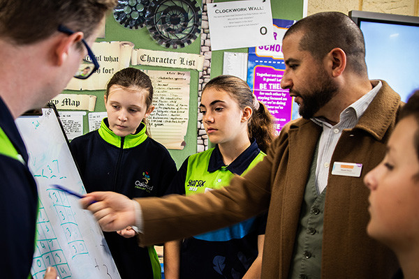 Scitech Professional Learning consultant Shyam Drury solving a maths problem with students using a whiteboard