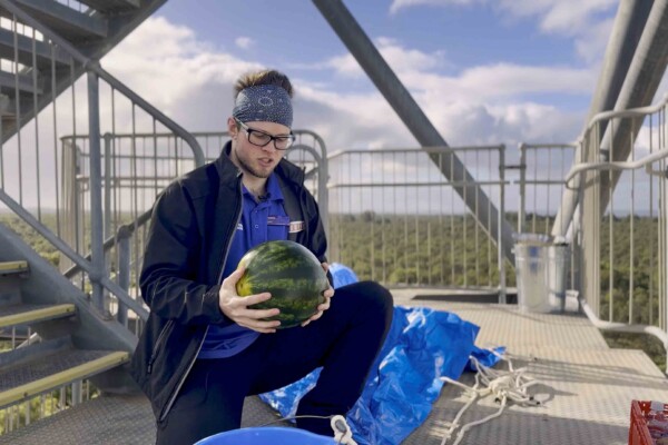 Scitech Senior Science Communicator Isaac Dawe gets ready to drop a watermelon with a parachute from a 45-metre tower to test how to make a safe Mars landing